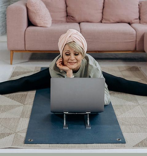 A woman sitting on the ground with her feet crossed.