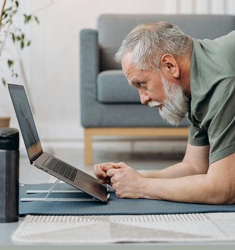 A man is on his laptop and looking at the screen.